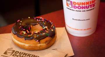 A chocolate glazed donut and a cup of coffee are arranged for a photograph at a Dunkin' Donuts Inc. store in West Orange, New Jersey, U.S., on Thursday, July 7, 2011. Sales at U.S. retailers surpassed analysts' estimates last month as discounts and lower gas prices in the U.S. enticed consumers to spend. Photographer: Emile Wamsteker/Bloomberg